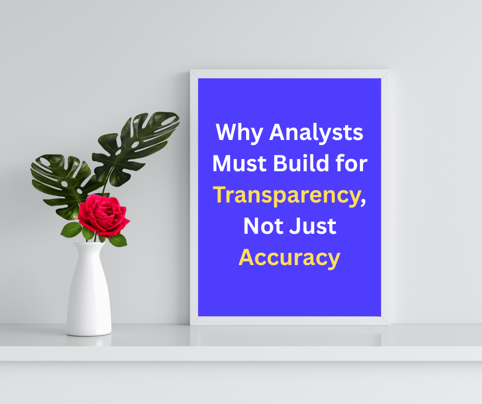Framed quote poster on a white shelf next to a vase with a red rose and green leaves. The poster reads: “Why Analysts Must Build for Transparency, Not Just Accuracy” in bold white and yellow text on a blue background.